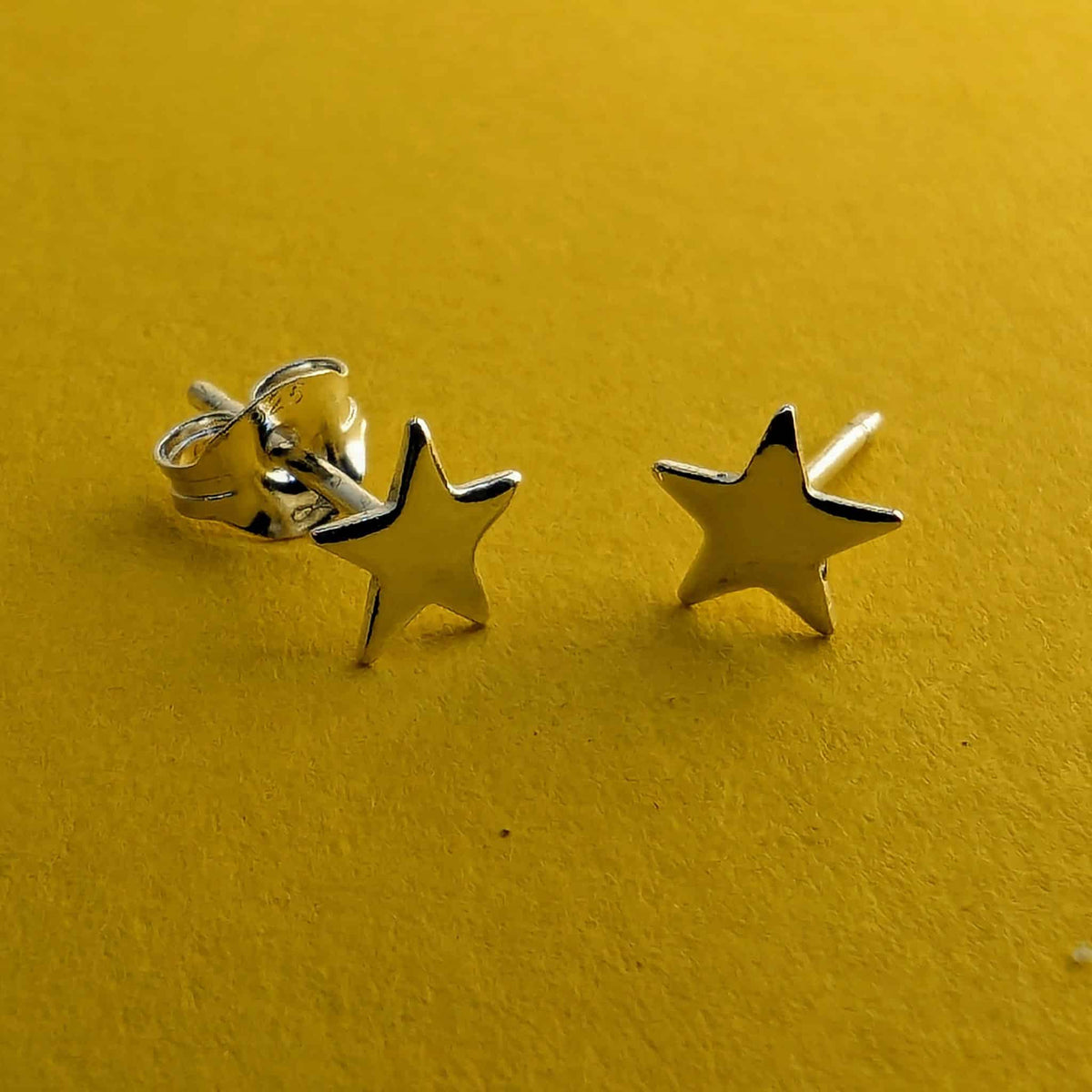 Tiny sterling silver star stud earrings with solid silver posts and butterfly backs