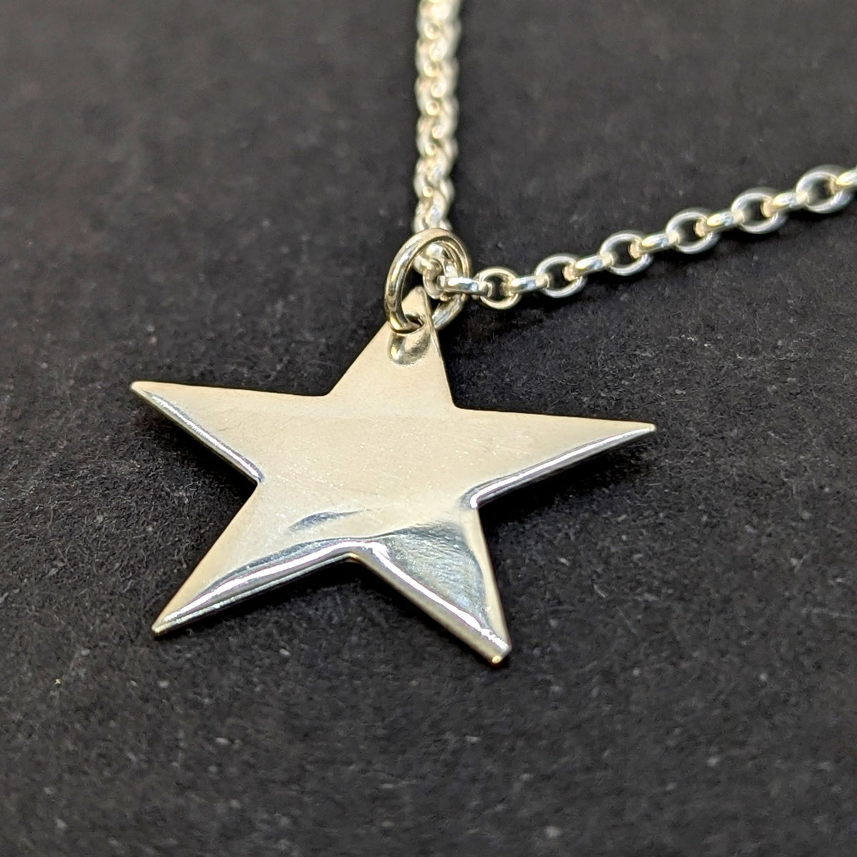 A bright, polished sterling silver star pendant